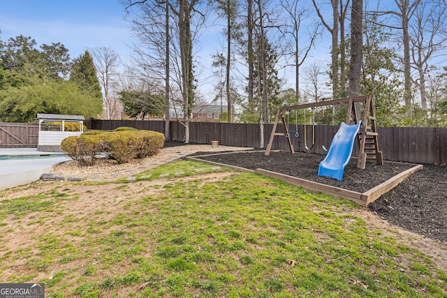 view of yard with a fenced in pool, a fenced backyard, and a playground