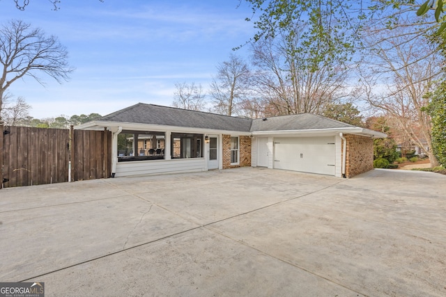 single story home with an attached garage, fence, brick siding, and driveway