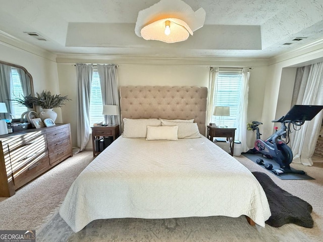 carpeted bedroom with ornamental molding, a raised ceiling, visible vents, and multiple windows