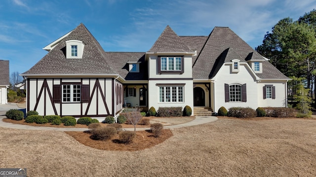 view of front of home featuring stucco siding and roof with shingles