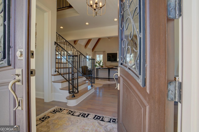 foyer entrance featuring stairway, wood finished floors, vaulted ceiling with beams, an inviting chandelier, and recessed lighting