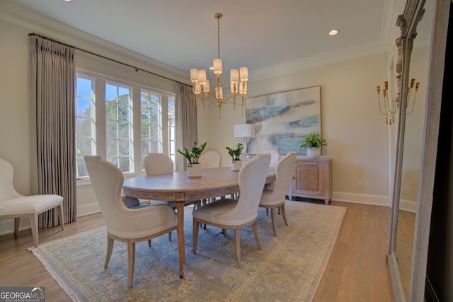 dining space featuring a notable chandelier, light wood-style flooring, baseboards, and crown molding