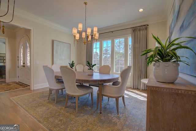 dining area with baseboards, wood finished floors, an inviting chandelier, crown molding, and recessed lighting