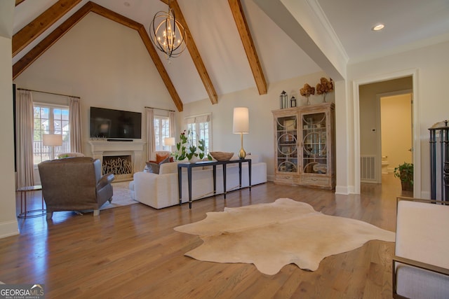 living area featuring high vaulted ceiling, a notable chandelier, a fireplace, visible vents, and beamed ceiling