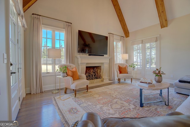 living room with high vaulted ceiling, plenty of natural light, beamed ceiling, and a premium fireplace