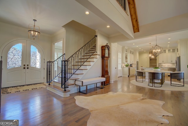 entrance foyer with a chandelier, french doors, light wood-style floors, and stairs