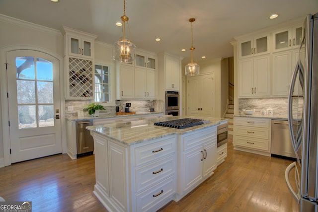 kitchen with appliances with stainless steel finishes, white cabinets, and a kitchen island