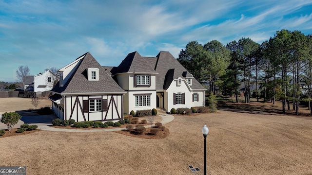 view of front facade featuring a shingled roof and stucco siding