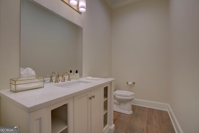 bathroom with baseboards, vanity, toilet, and wood finished floors