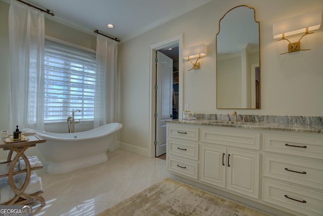 bathroom with a freestanding bath, baseboards, crown molding, and vanity