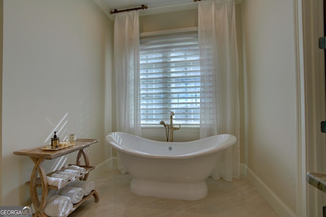 full bathroom with a freestanding bath and baseboards