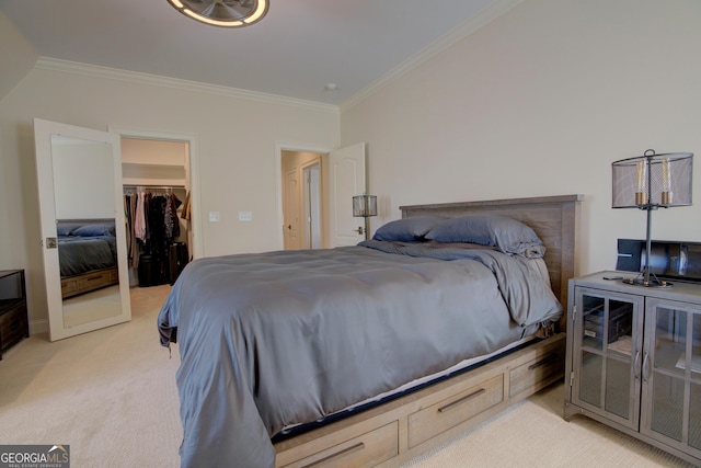 bedroom featuring ornamental molding, a closet, a walk in closet, and light colored carpet