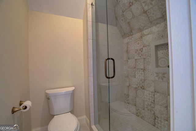 bathroom with a shower stall, toilet, and baseboards