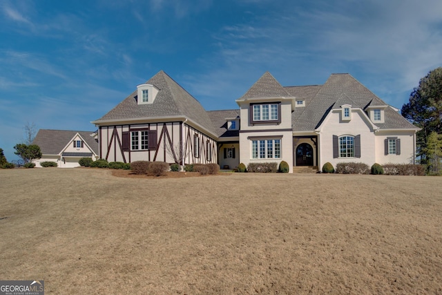 view of front facade with roof with shingles and stucco siding