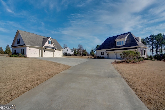 view of side of home featuring a garage, driveway, a shingled roof, and a lawn