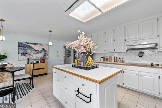 kitchen featuring white cabinets, under cabinet range hood, black electric cooktop, and light countertops