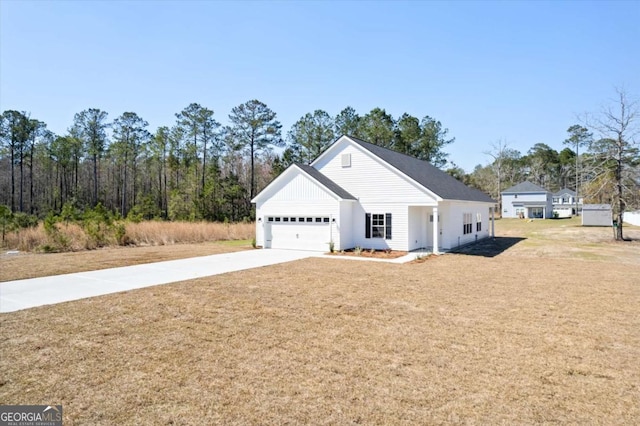 view of front facade featuring a front yard, concrete driveway, and an attached garage