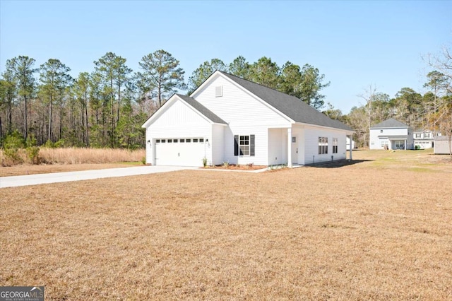 view of front of house featuring a garage, driveway, and a front yard