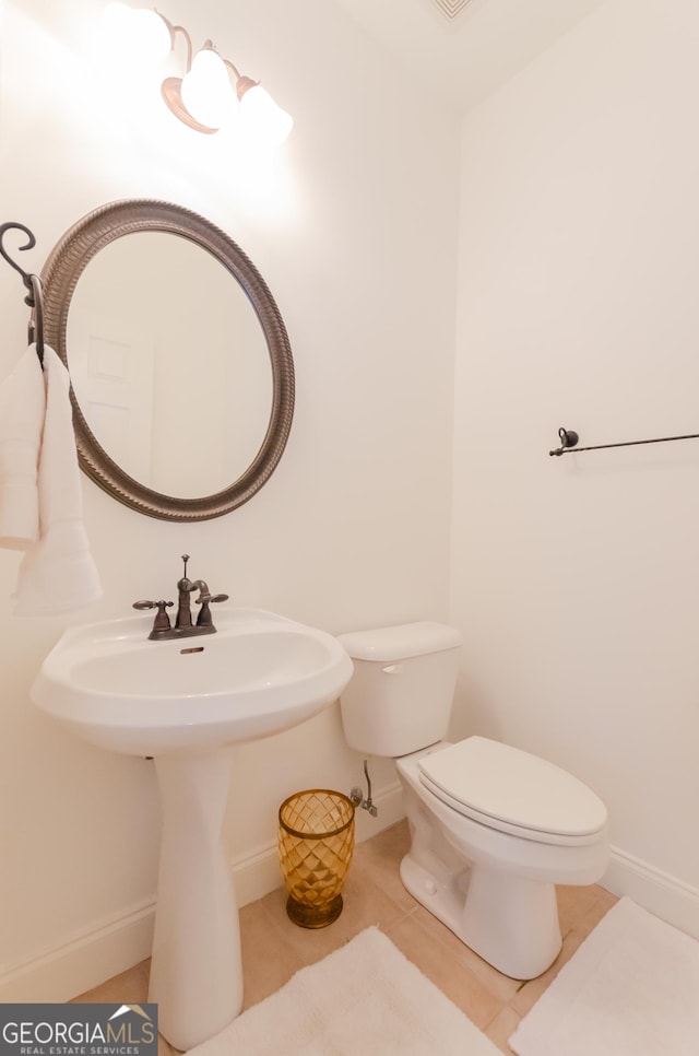 2474 Starfire Ln, Loganville, GA 30052 - half bathroom featuring toilet, baseboards, a sink, and tile patterned flooring