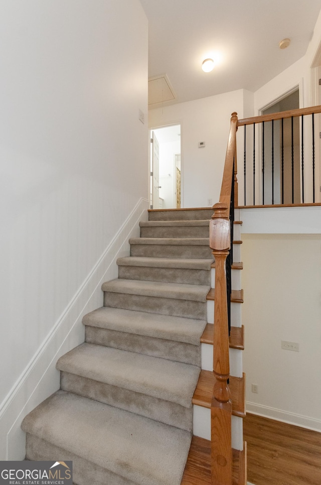 2474 Starfire Ln, Loganville, GA 30052 - stairs with attic access, wood finished floors, and baseboards