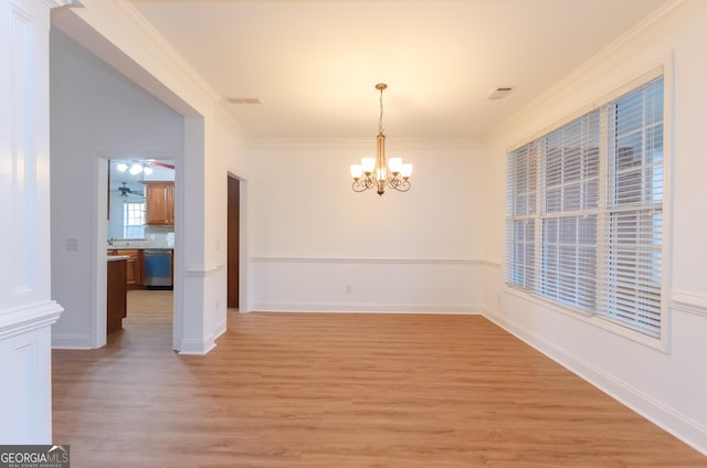 2474 Starfire Ln, Loganville, GA 30052 - unfurnished dining area featuring a chandelier, light wood-style flooring, crown molding, and a ceiling fan