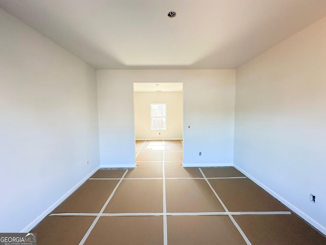 unfurnished room with baseboards and tile patterned floors