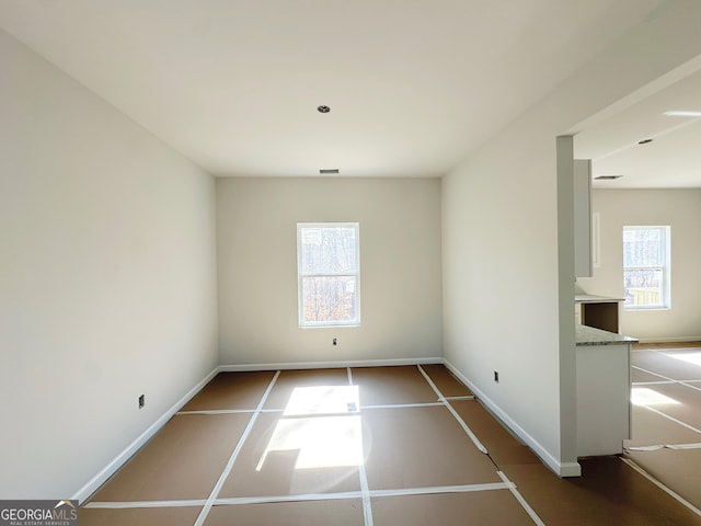 unfurnished room featuring baseboards and visible vents