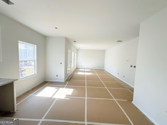 spare room featuring tile patterned flooring, visible vents, and baseboards