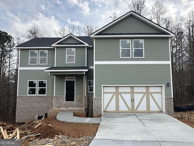 view of front of house featuring a garage, brick siding, and concrete driveway