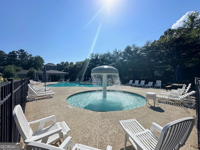 community pool featuring a patio and fence