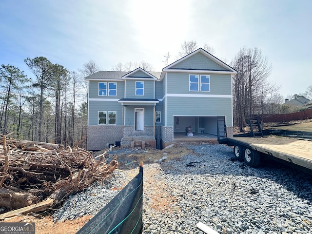 view of front facade with driveway, a garage, and brick siding