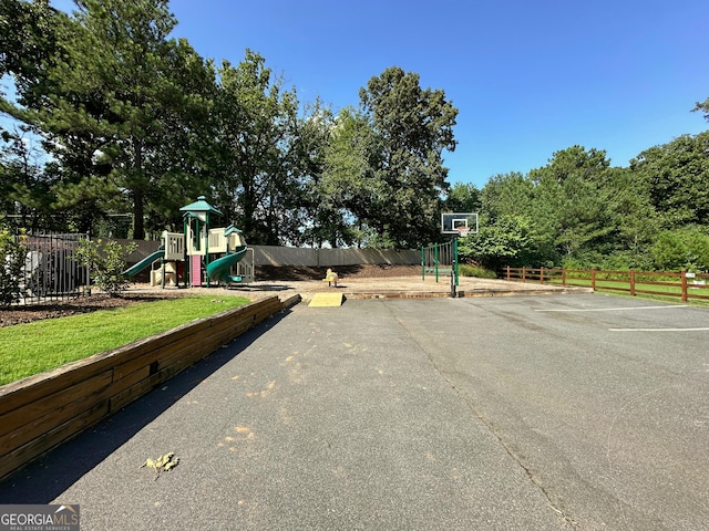 exterior space featuring playground community, fence, and community basketball court