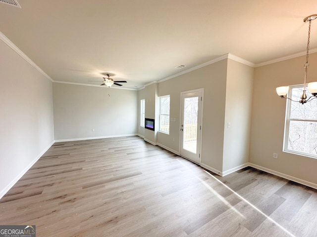 unfurnished living room with light wood-style floors, crown molding, and ceiling fan with notable chandelier