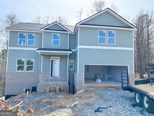 view of front of home featuring brick siding, a patio, driveway, and an attached garage