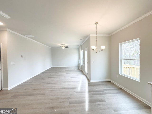 unfurnished dining area featuring ceiling fan with notable chandelier, light wood finished floors, ornamental molding, and baseboards