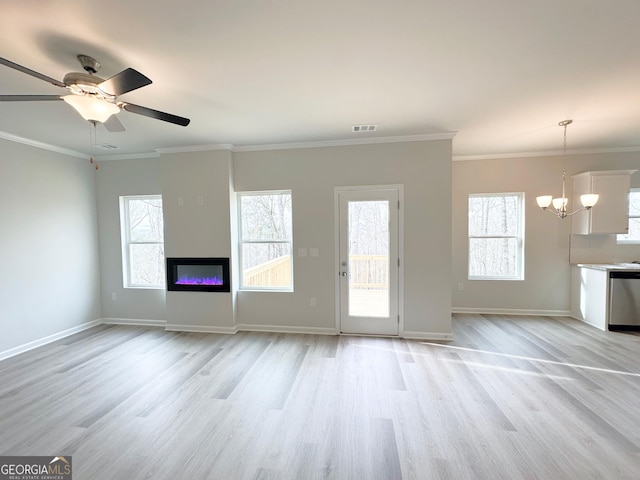 unfurnished living room with crown molding, visible vents, and plenty of natural light