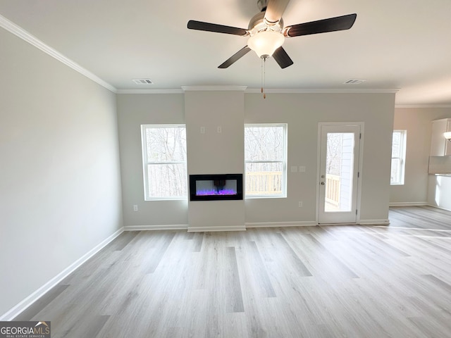 unfurnished living room featuring baseboards, a glass covered fireplace, crown molding, and wood finished floors