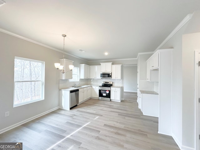 kitchen featuring stainless steel appliances, a sink, crown molding, and decorative backsplash