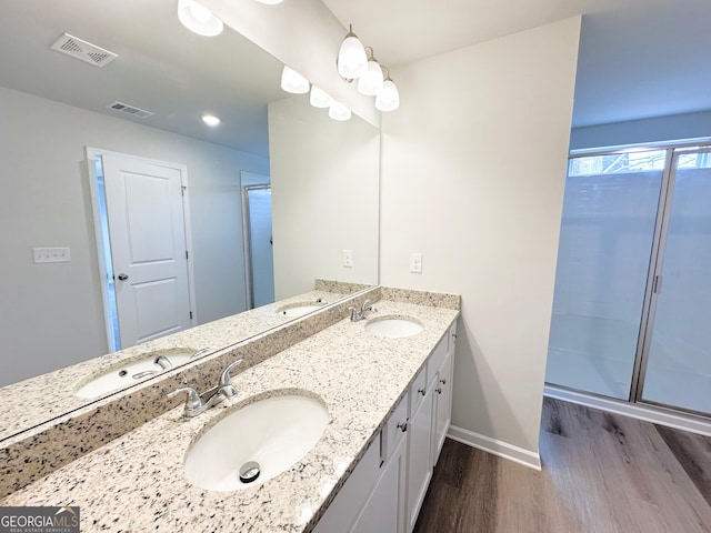 bathroom featuring wood finished floors, a sink, and visible vents