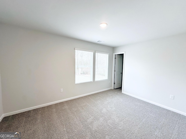 carpeted empty room with baseboards and visible vents