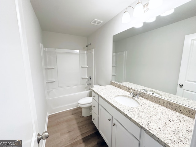 bathroom with bathtub / shower combination, toilet, wood finished floors, vanity, and visible vents