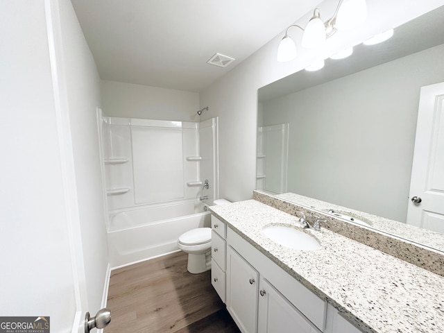 full bathroom with bathing tub / shower combination, visible vents, toilet, vanity, and wood finished floors