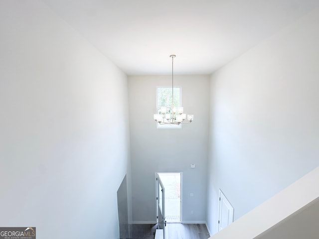 entrance foyer featuring an inviting chandelier, baseboards, and wood finished floors