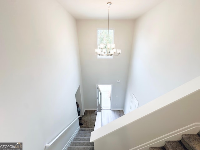 stairway featuring a notable chandelier and baseboards