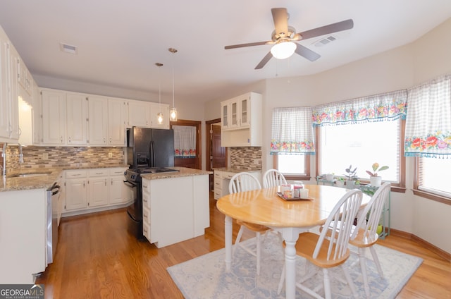 dining room featuring light wood finished floors, visible vents, and a wealth of natural light