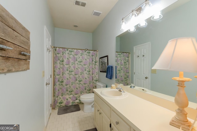 bathroom featuring toilet, vanity, visible vents, and tile patterned floors