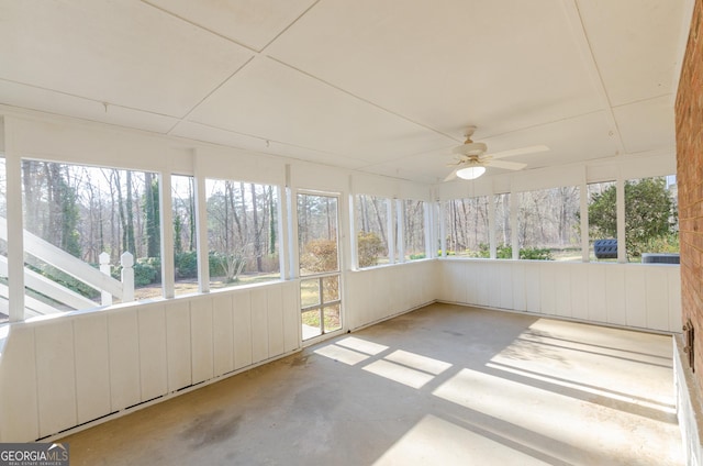 unfurnished sunroom featuring a ceiling fan