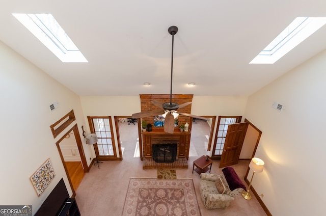 carpeted living room with lofted ceiling, visible vents, ceiling fan, and a fireplace