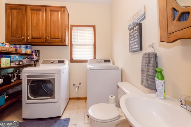 clothes washing area featuring laundry area, light tile patterned floors, washer and clothes dryer, and a sink