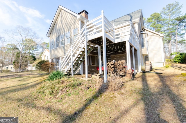 exterior space with a deck, a chimney, and stairway